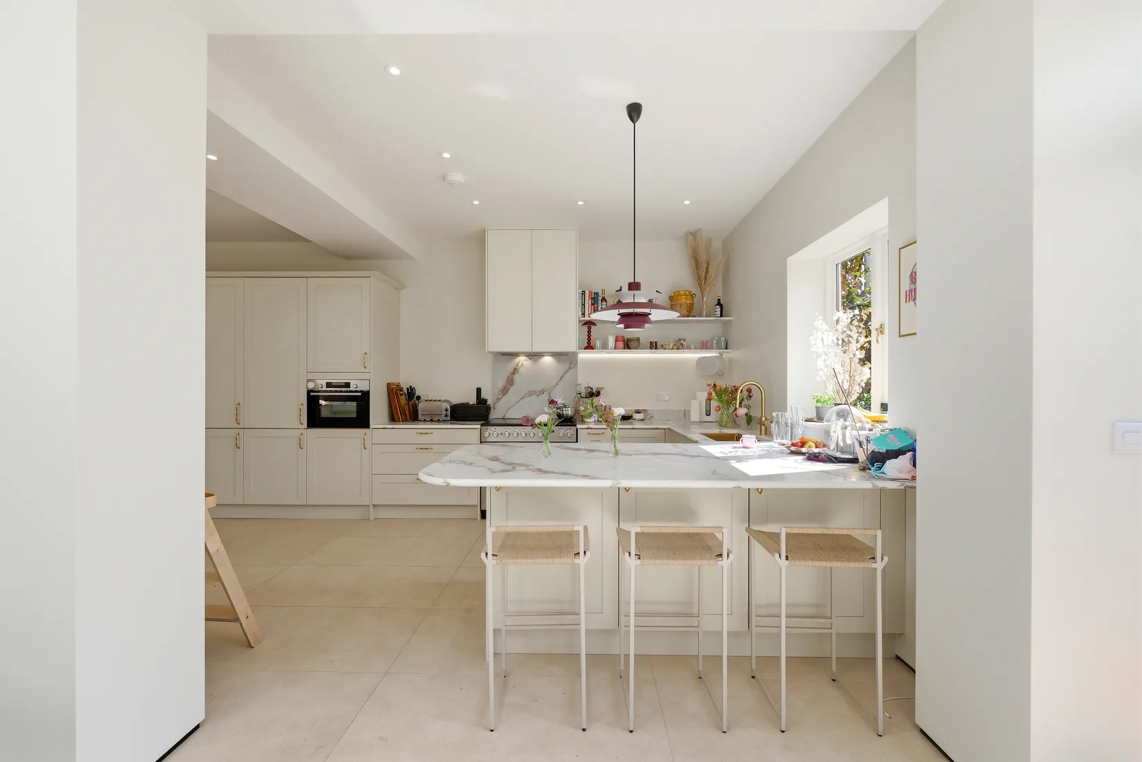 Open-plan kitchen with a marble-topped island and bar seating